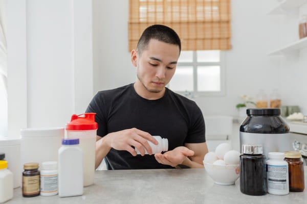 サプリを飲む坊主の男性