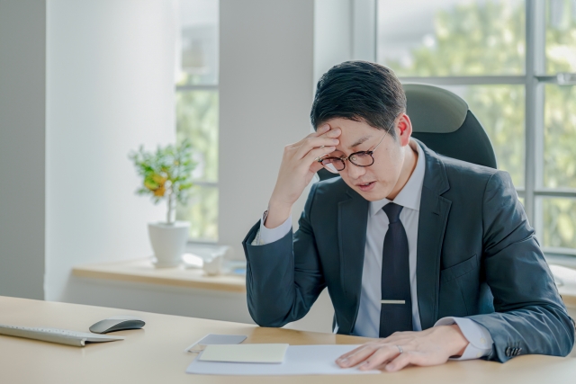 ストレスで頭を抱えている男性の画像